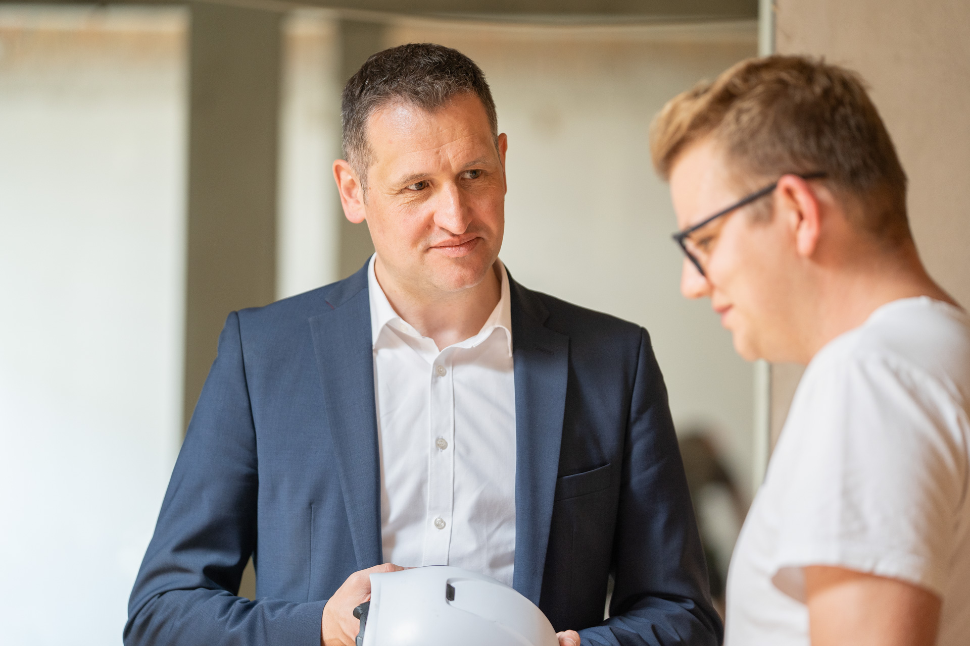 Landtagswahlkandidat Christoph Stetter im Gespräch mit einem Polier auf einer Baustelle in Singen