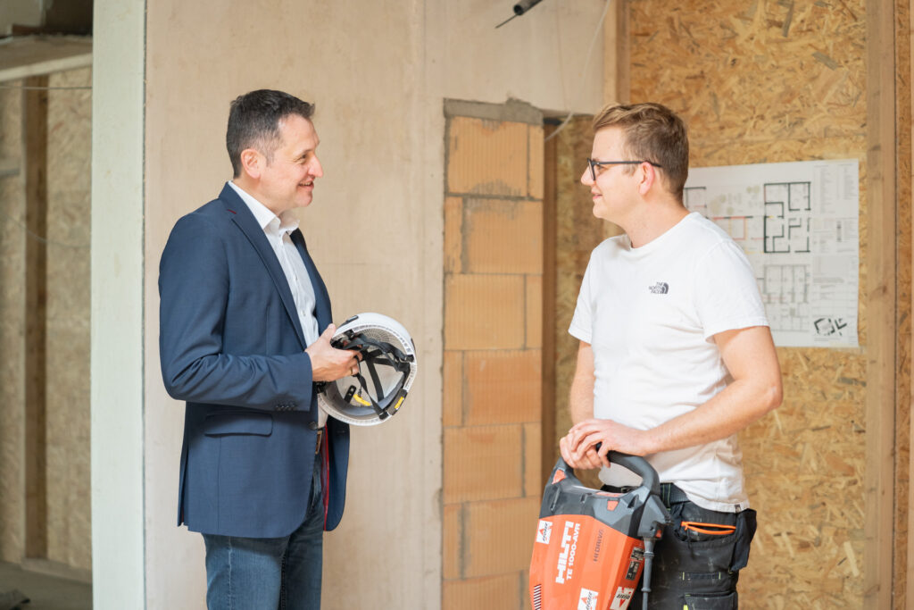 Landtagswahlkandidat Christoph Stetter im Gespräch mit einem Polier auf einer Baustelle in Singen