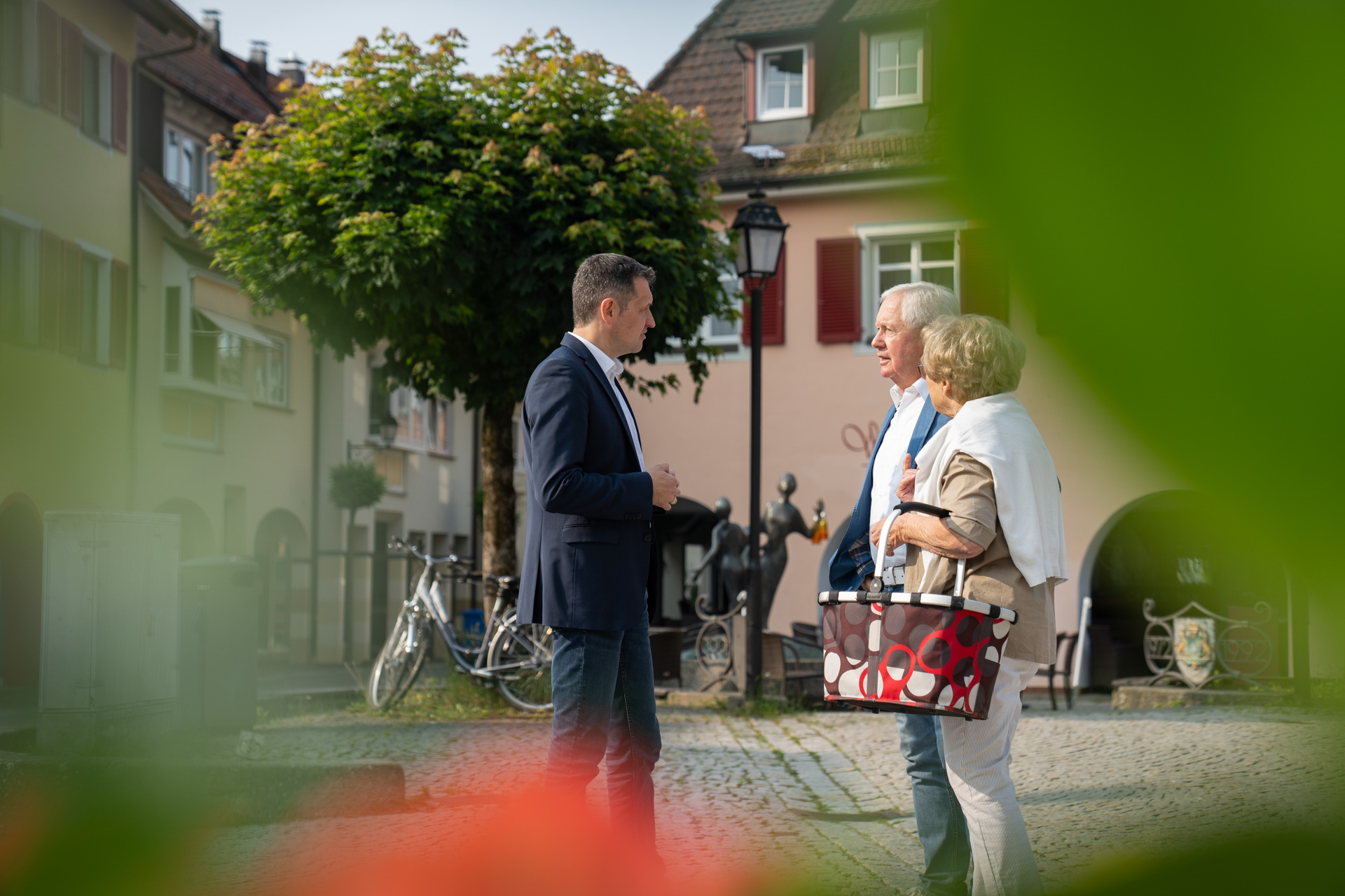 Christoph Stetter im Gespräch mit älterem Senioren-Ehepaar auf dem Gustav-Hammer-Platz in Stockach