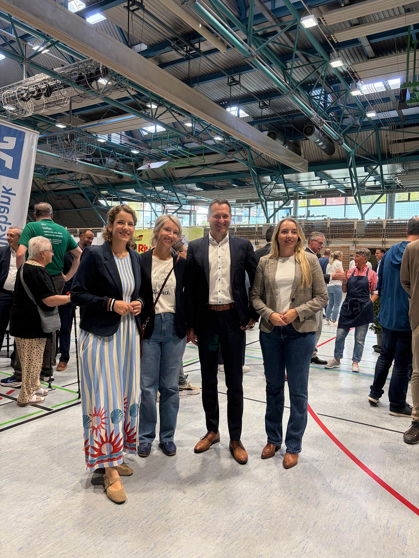 Vier Personen, darunter Christoph Stetter, posieren auf der Tischmesse Stockach in einer großen Halle mit Industrie- und Beleuchtungsstrukturen im Hintergrund.