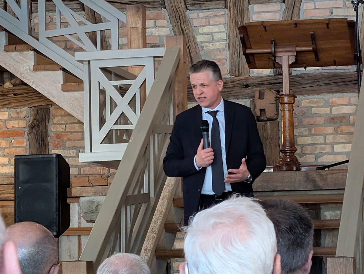 Innovativer Redner Christoph Stetter bei einer Veranstaltung in rustikalem Ambiente mit Holz und Backstein, spricht vor Publikum, präsentiert moderne Kommunikation und Unternehmensstrategien.