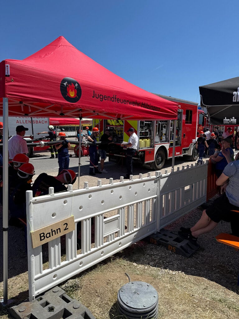 Feuerwehrjugend und Einsatzfahrzeug beim Kreisfeuerwehrtag in Eigeltingen, Deutschland, bei sonnigem Wetter.