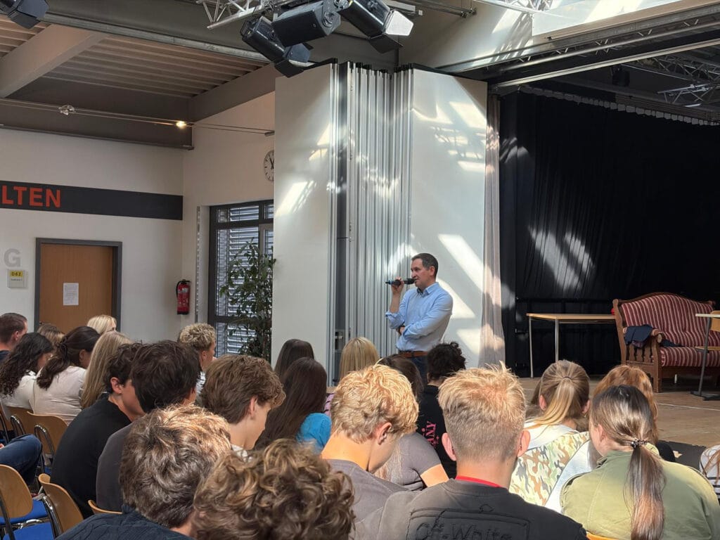 Landtagsabgeordneter Christoph Stetter spricht bei einer Veranstaltung mit Schülerinnen und Schülern im Schulsaal.