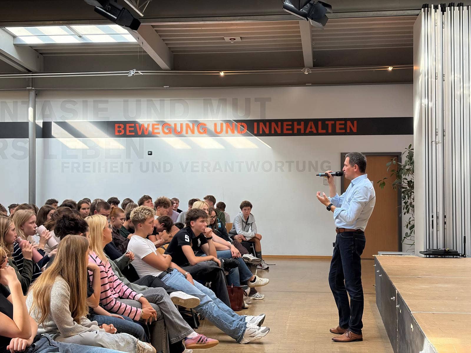 Christoph Stetter spricht bei einer Veranstaltung mit Schülerinnen und Schülern über Bewegung und Inhalte.