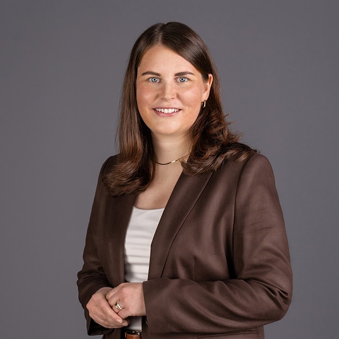 Professionelles Portrait von Christoph Stetter, Kontaktperson auf der Webseite, in formeller Kleidung vor grauem Hintergrund.