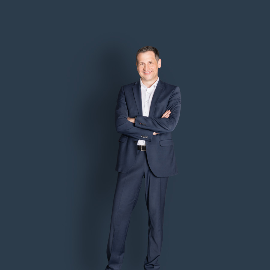 Foto des ganzen Körpers von Christoph Stetter, dem CDU-Kandidat zur Landtagswahl 2026, im blauen Anzug vor dunkelblauem Hintergrund als Pressefoto